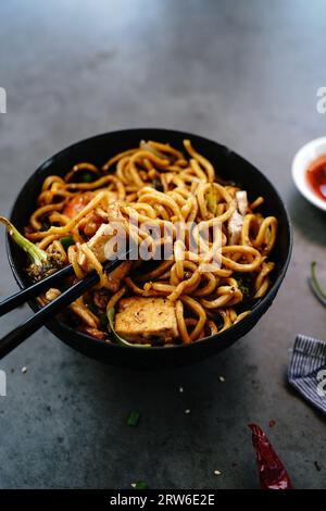 Spaghetti di lomeina fritti in padella asiatici fatti in casa con pollo e verdure Foto Stock