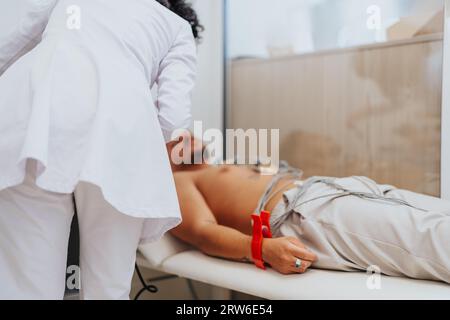 Cardiologo professionista che analizza i risultati dei test dell'elettrocardiogramma e consiglia il paziente durante la consultazione. Foto Stock