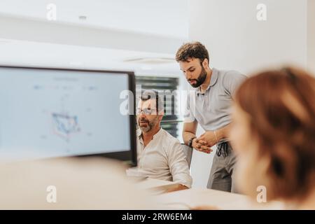 In questo dinamico ambiente di ufficio, un gruppo di colleghi collabora, elabora strategie e lavora per la crescita e il successo dell'azienda. Foto Stock