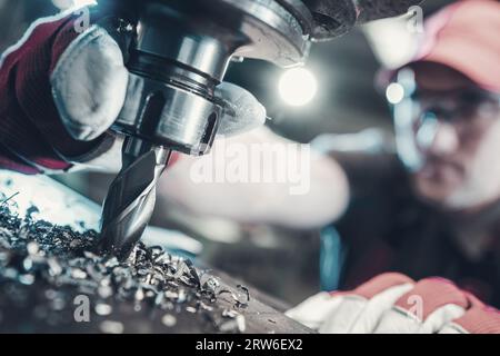 Operaio che lavora con i metalli che utilizza una perforatrice per metalli per impieghi gravosi, di grado professionale Foto Stock