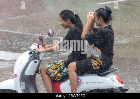 SAMUT PRAKAN, THAILANDIA, giugno 06 2023, giovane donna guida una motocicletta sotto la pioggia battente Foto Stock