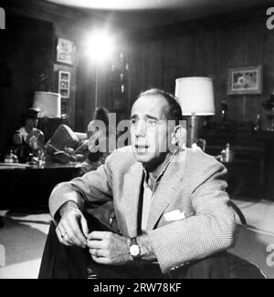 HUMPHREY BOGART ritratto sincero senza parrucchiere in posizione non identificata da ERNIE STOUT intorno al maggio 1954 con sua moglie LAUREN BACALL sullo sfondo Foto Stock