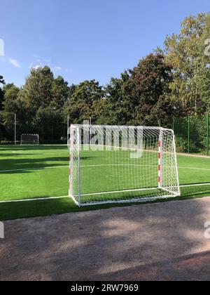 campo da calcio scolastico vuoto, cancelli in primo piano, prato verde, paesaggio Foto Stock