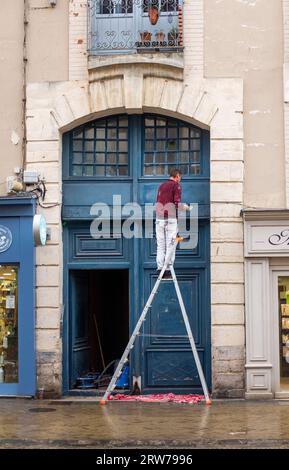 Un uomo che dipinge una porta nella grande Rue a Dieppe , Normandia Dieppe è un porto di pescatori sulla costa normanna della Francia settentrionale Foto Stock
