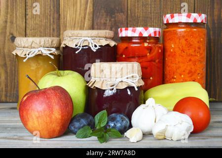 Frutta e verdura conservate e fresche su fondo di legno. Conservare i cibi casalinghi. Foto Stock