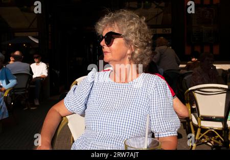 Donna seduta in un bar a Dieppe , Normandia, Dieppe è un porto di pescatori sulla costa normanna della Francia settentrionale Foto Stock