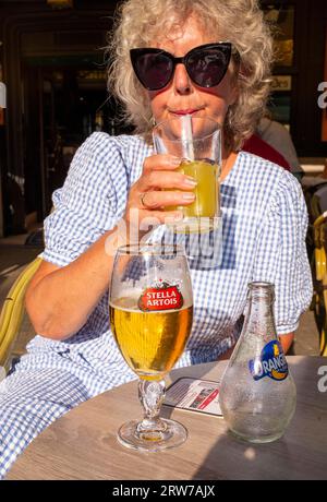 Donna seduta in un bar a Dieppe , Normandia, Dieppe è un porto di pescatori sulla costa normanna della Francia settentrionale Foto Stock