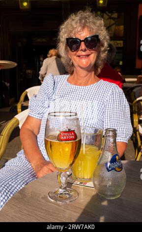 Donna seduta in un bar a Dieppe , Normandia, Dieppe è un porto di pescatori sulla costa normanna della Francia settentrionale Foto Stock