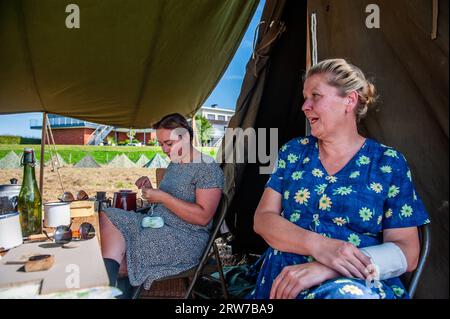 Nijmegen, Gelderland, Paesi Bassi. 16 settembre 2023. Due donne si esibiscono indossando abiti retrò. Questo mese saranno 79 anni fa che le truppe della 82esima Divisione aviotrasportata americana attraversarono il fiume Waal a Nijmegen, per liberare la città dagli occupanti tedeschi. Per questo motivo, un accampamento della seconda guerra mondiale fu ricreato sulla riva del fiume, dove i reenattori (partecipanti in autentico abbigliamento militare) portarono i visitatori indietro nel tempo con la storia vivente. (Immagine di credito: © Ana Fernandez/SOPA Images via ZUMA Press Wire) SOLO USO EDITORIALE! Non per USO commerciale! Foto Stock