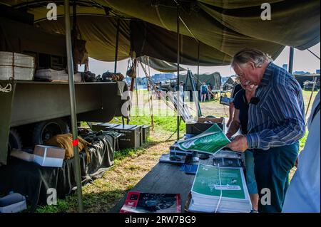 Nijmegen, Gelderland, Paesi Bassi. 16 settembre 2023. La gente sta guardando alcuni volantini informativi. Questo mese saranno 79 anni fa che le truppe della 82esima Divisione aviotrasportata americana attraversarono il fiume Waal a Nijmegen, per liberare la città dagli occupanti tedeschi. Per questo motivo, un accampamento della seconda guerra mondiale fu ricreato sulla riva del fiume, dove i reenattori (partecipanti in autentico abbigliamento militare) portarono i visitatori indietro nel tempo con la storia vivente. (Immagine di credito: © Ana Fernandez/SOPA Images via ZUMA Press Wire) SOLO USO EDITORIALE! Non per USO commerciale! Foto Stock