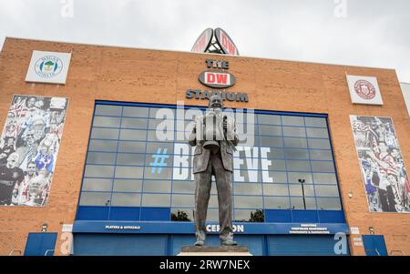 Una statua dell'ex proprietario del Wigan Athletic Dave Whelan raffigurata tenendo la fa Cup in alto fuori dal DW Stadium di Wigan nel settembre 2023. Creato da se Foto Stock