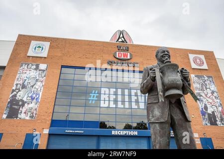 Una statua dell'ex proprietario del Wigan Athletic Dave Whelan raffigurata tenendo la fa Cup in alto fuori dal DW Stadium di Wigan nel settembre 2023. Creato da se Foto Stock