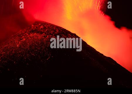 Vista ravvicinata del vulcano Etna sulla grande eruzione di lava di nocturne alla vista retroilluminata della silhouette del cratere superiore Foto Stock