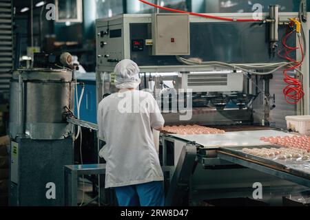 I pasticceri lavorano sulla linea di produzione del marshmallow. Foto Stock