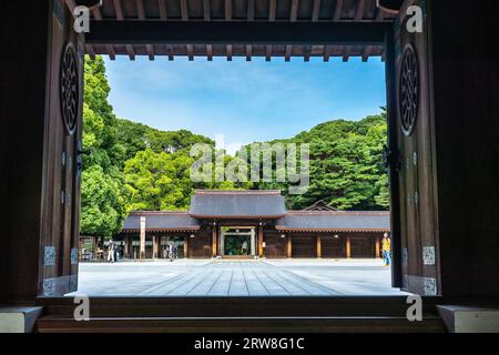 Le enormi porte di legno si affacciano sulla recinzione sacra e sul cortile del santuario Meiji Jingu, situato all'interno di una foresta di 170 ettari, a Shibuya, Tokyo, Giappone. Il santuario shintoista è dedicato agli spiriti dell'imperatore Meiji e di sua moglie, l'imperatrice Shoken. Foto Stock