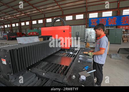 LUANNAN COUNTY, Cina - 15 settembre 2021: I lavoratori stanno manipolando macchine utensili CNC per lavorare parti metalliche, Cina settentrionale Foto Stock