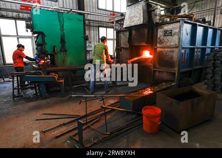 CONTEA DI LUANNAN, Cina - 24 settembre 2021: I lavoratori lavorano intensamente su una linea di produzione di forgiatura in uno stabilimento di produzione di utensili hardware nel nord della Cina Foto Stock