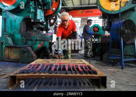 CONTEA DI LUANNAN, Cina - 24 settembre 2021: I lavoratori lavorano intensamente su una linea di produzione di forgiatura in uno stabilimento di produzione di utensili hardware nel nord della Cina Foto Stock