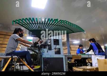 LUANNAN COUNTY, Cina - 24 settembre 2021: I lavoratori lavorano duramente sulla linea di assemblaggio di escavatori e rastrelli in acciaio in una società di produzione di utensili hardware in N Foto Stock