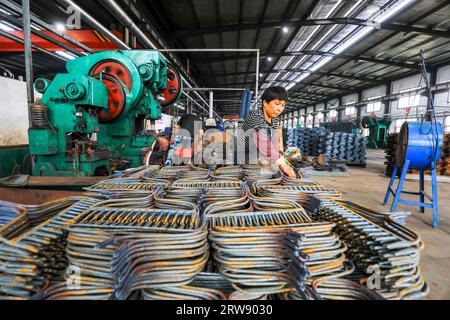 CONTEA DI LUANNAN, Cina - 24 settembre 2021: I lavoratori lavorano intensamente su una linea di produzione di forgiatura in uno stabilimento di produzione di utensili hardware nel nord della Cina Foto Stock