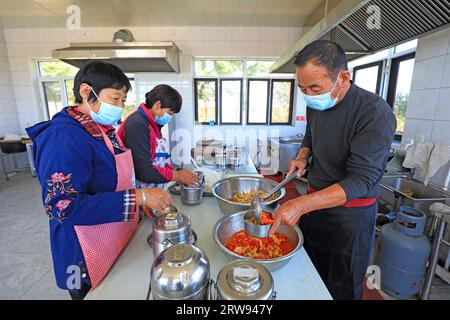 LUANNAN COUNTY, Cina - 11 ottobre 2021: Il personale di cucina della piccola mensa per anziani serve cibo e verdure per anziani, Chin Nord Foto Stock