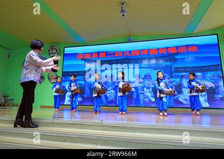 LUANNAN COUNTY, Cina - 18 ottobre 2021: Un artista performativo di Pingju guida i bambini ad imparare Pingju, Cina settentrionale Foto Stock