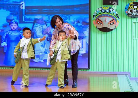 LUANNAN COUNTY, Cina - 18 ottobre 2021: Un artista performativo di Pingju guida i bambini ad imparare Pingju, Cina settentrionale Foto Stock