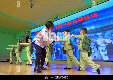 LUANNAN COUNTY, Cina - 18 ottobre 2021: Un artista performativo di Pingju guida i bambini ad imparare Pingju, Cina settentrionale Foto Stock