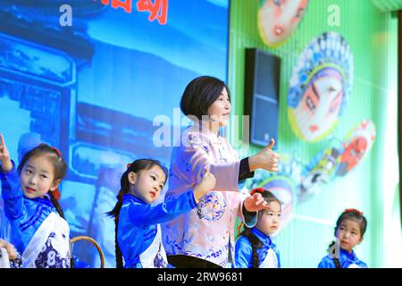 LUANNAN COUNTY, Cina - 18 ottobre 2021: Un artista performativo di Pingju guida i bambini ad imparare Pingju, Cina settentrionale Foto Stock