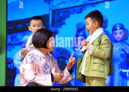 LUANNAN COUNTY, Cina - 18 ottobre 2021: Un artista performativo di Pingju guida i bambini ad imparare Pingju, Cina settentrionale Foto Stock