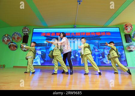 LUANNAN COUNTY, Cina - 18 ottobre 2021: Un artista performativo di Pingju guida i bambini ad imparare Pingju, Cina settentrionale Foto Stock