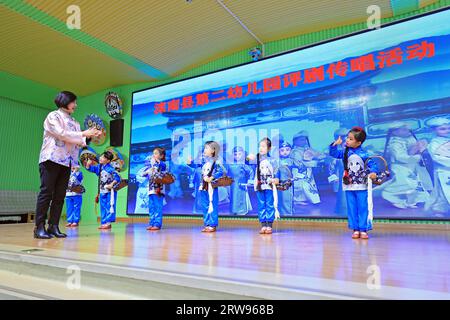 LUANNAN COUNTY, Cina - 18 ottobre 2021: Un artista performativo di Pingju guida i bambini ad imparare Pingju, Cina settentrionale Foto Stock