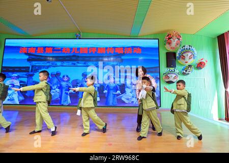 LUANNAN COUNTY, Cina - 18 ottobre 2021: Un artista performativo di Pingju guida i bambini ad imparare Pingju, Cina settentrionale Foto Stock