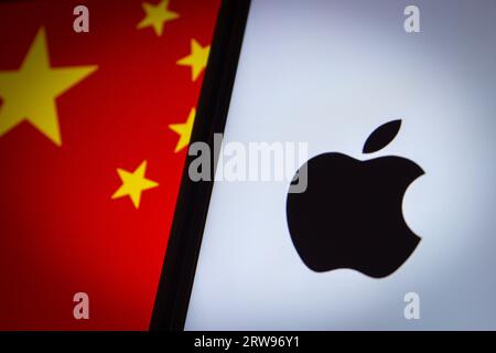 Vancouver, CANADA - 13 settembre 2023: Logo Apple Inc. Visibile sullo schermo dell'iPhone sullo sfondo della bandiera cinese Foto Stock
