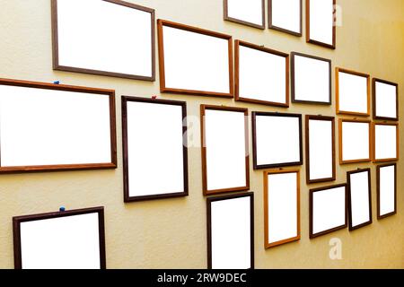 Ci sono molte cornici vuote sulla parete gialla. Foto Stock