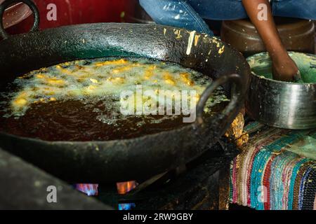 Frittura profonda di peperoncino grande all'olio di mosto nel negozio di strada o piatti locali dell'india Mirchi badda in strada Foto Stock