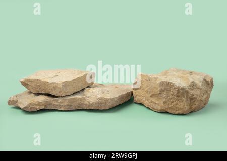 Podio di pietra per la presentazione di prodotti cosmetici. Sfondo astratto minimo. Due forme di roccia. Sfondo Studio verde chiaro. Scenografia da mostrare. Vetrina Foto Stock