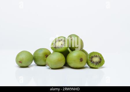 Mini kiwi, frutti interi e tagliati a metà (Actinidia arguta) Foto Stock