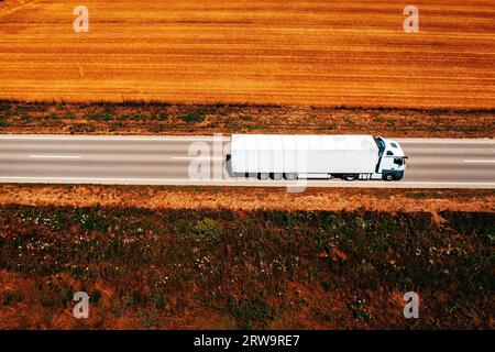 Autocarro bianco in autostrada attraverso paesaggi di campagna, ripresa aerea dal drone pov Foto Stock