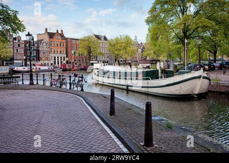 Paesaggio urbano della città di Amsterdam, case galleggianti sul canale Groenburgwal e sul fiume Amstel, Paesi Bassi, provincia dell'Olanda settentrionale Foto Stock