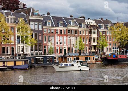 Vista sul fiume Amsterdam, case e case galleggianti sul fiume Amstel nei Paesi Bassi, provincia dell'Olanda settentrionale Foto Stock