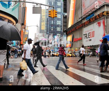NEW YORK CITY, USA, 12 GIUGNO: Gente che attraversa una strada a Rainy Times Square. 12 giugno 2012 a New York, Stati Uniti Foto Stock