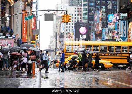 NEW YORK CITY, USA, 12 GIUGNO: Gente che attraversa una strada in Rainy Times Square. 12 giugno 2012 a New York, Stati Uniti Foto Stock