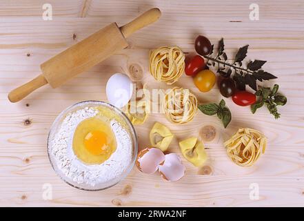 Ingredienti per preparare la pasta su una tavola di legno Foto Stock