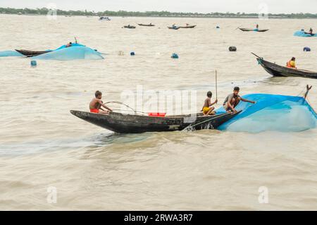 Sunderban, Bangladesh, circa luglio 2012: Giovani ragazzi siedono su una barca di legno sul fiume e pescano a Sunderban, Bangladesh. Documentario editoriale Foto Stock