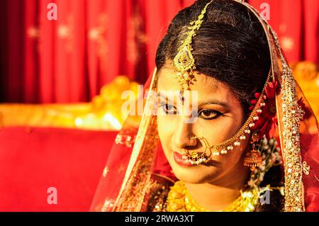 Dhaka, Bangladesh, circa luglio 2012: Foto di una giovane sposa dai capelli neri con piercing e con velo scintillante d'oro sulla testa che posa durante il suo matrimonio Foto Stock
