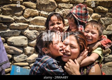 Dolpo, Nepal, circa giugno 2012: I bambini piccoli abbracciano la madre e sorridono con gioia alla fotocamera a Dolpo, Nepal. Documentario editoriale Foto Stock