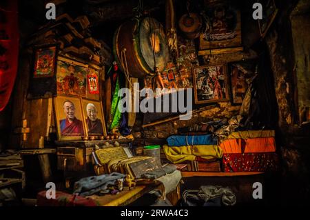 Dolpo, Nepal, circa giugno 2012: Foto di parte della stanza con molte cose come ritratti di monaci e persone famose, grande tamburo e abiti colorati Foto Stock