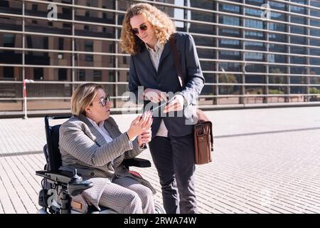 uomo che mostra un tablet a una donna d'affari Foto Stock