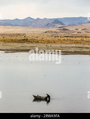 Man and young girl launching small boat in Pyramid Lake Stock Photo